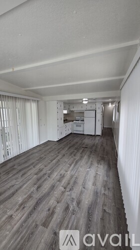 A room with wooden flooring and white walls.