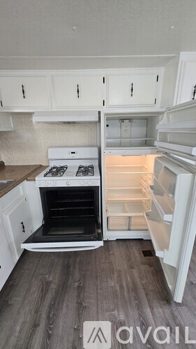 A kitchen with a stove top oven and cabinets.