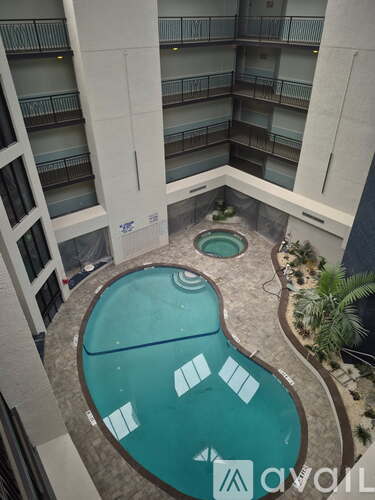 A small pool with a hot tub in the middle of a balcony.