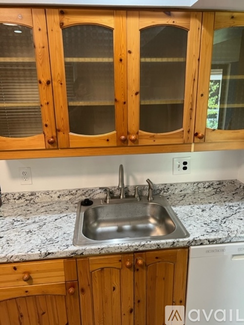 A kitchen with wooden cabinets and a marble countertop.