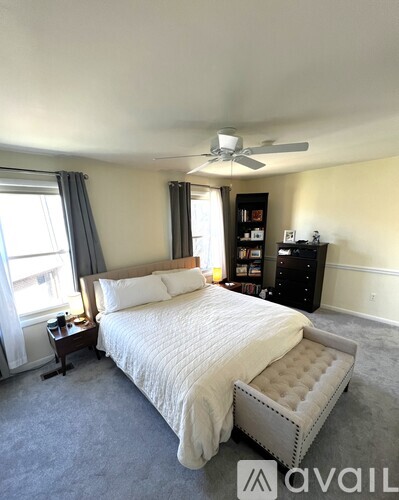 A bedroom with a large bed and a ceiling fan.