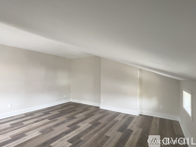 A room with wooden flooring and white walls.