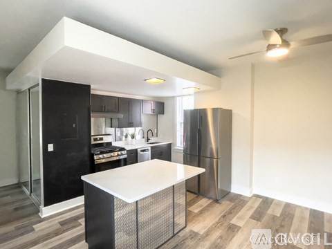 A modern kitchen with a black refrigerator and a white island.