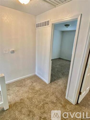 A room with a carpeted floor and a mirror on the wall.