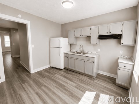 A kitchen with white appliances and cabinets.