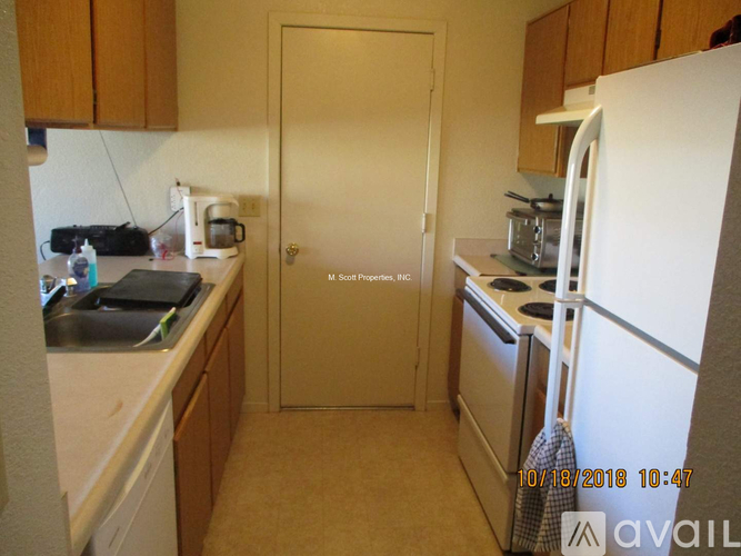 A kitchen with a white fridge, white microwave, and white oven.