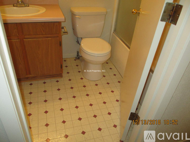 A bathroom with a toilet, sink, and tiled floor.