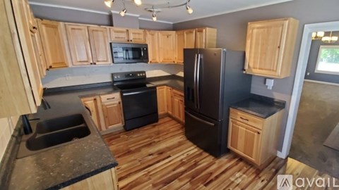 A kitchen with wooden cabinets and black appliances.