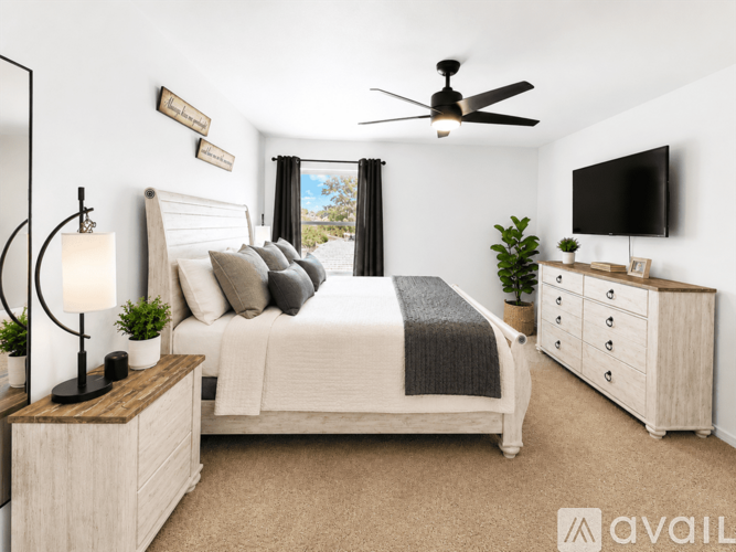 A bedroom with a bed, dresser, and ceiling fan.