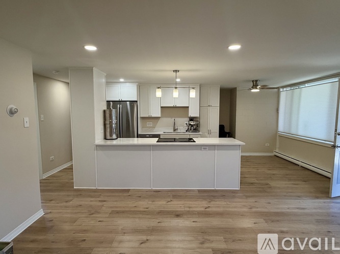 A spacious kitchen with white cabinets and a central island.