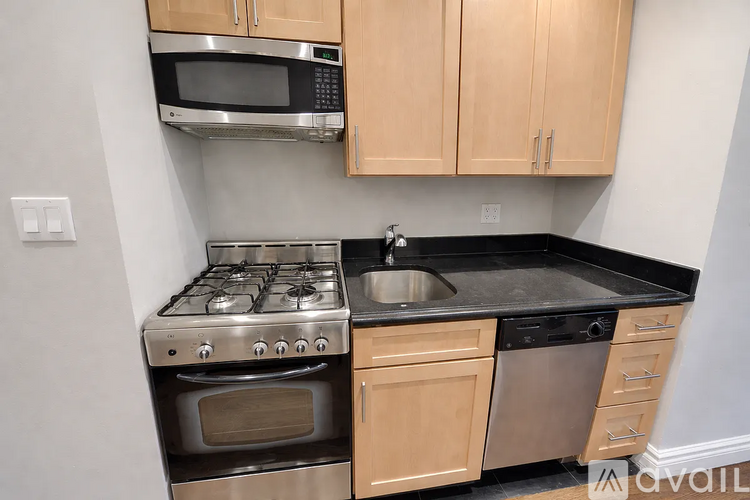 A kitchen with a stove, oven, microwave, and sink.