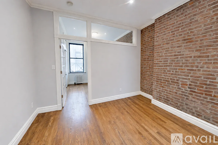 A room with wooden floors and a brick wall.