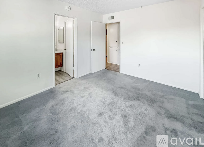 A spacious room with a grey floor and white walls.