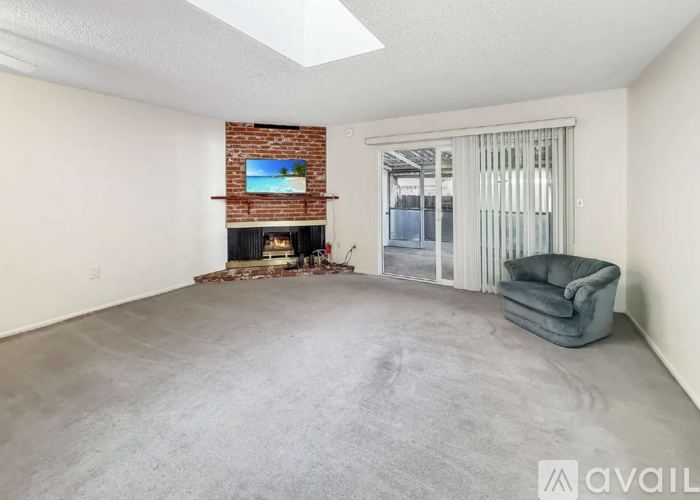 A living room with a fireplace and a grey sofa.