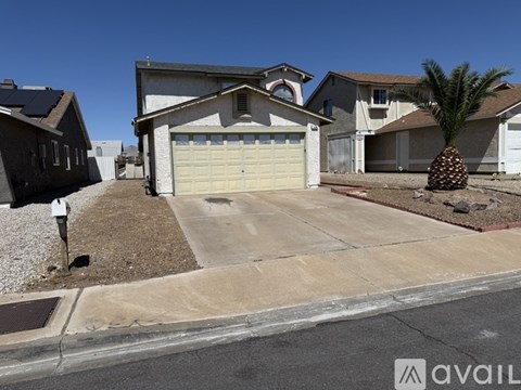 A house with a garage and a palm tree in front.