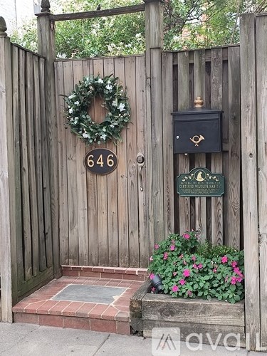 A wooden gate with a wreath and a mailbox on it.