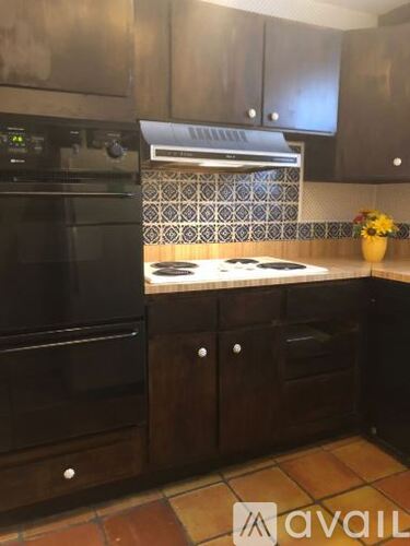 A kitchen with black appliances and wooden cabinets.