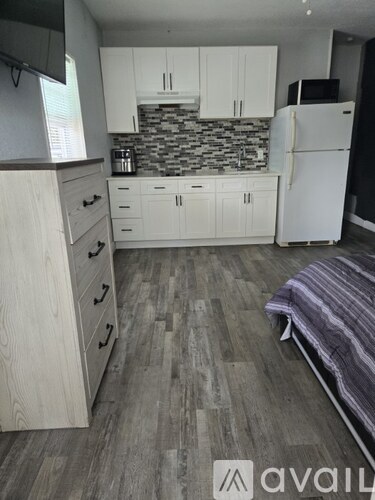 A kitchen with a white refrigerator and wooden cabinets.