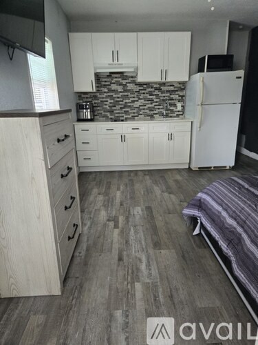 A kitchen with a white refrigerator and wooden cabinets.