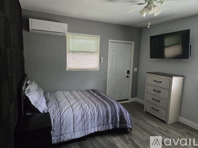A bedroom with a bed, dresser, and television.