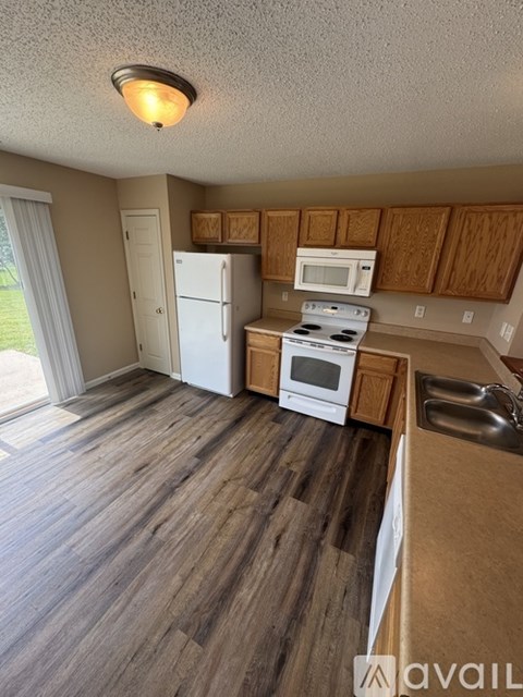 A kitchen with wooden cabinets and a white fridge.
