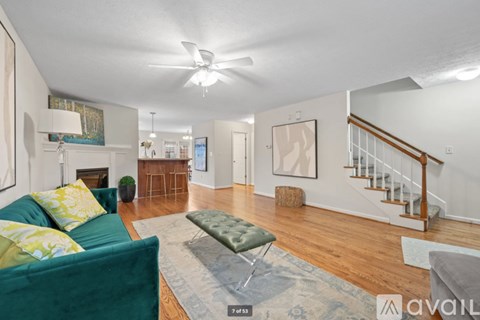 A living room with a green couch and a rug.