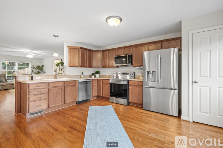 A kitchen with wooden cabinets and a blue rug on the floor.