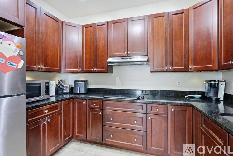 A kitchen with wooden cabinets and a black counter top.