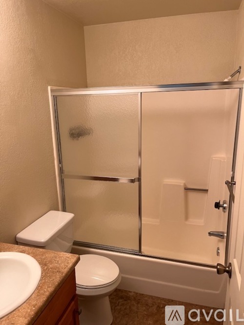 A bathroom with a toilet, sink, and shower.
