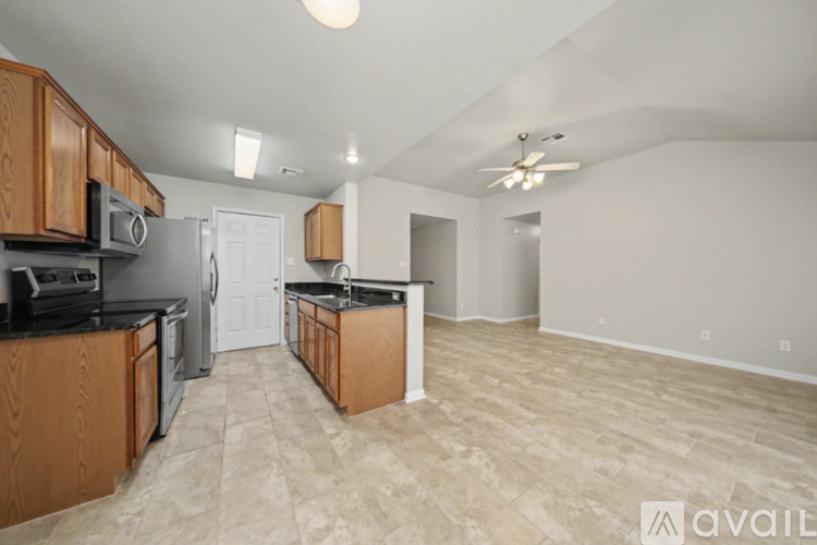 A kitchen with wooden cabinets and a black countertop.