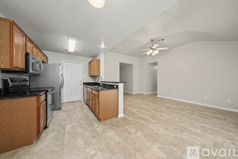 A kitchen with wooden cabinets and a black countertop.