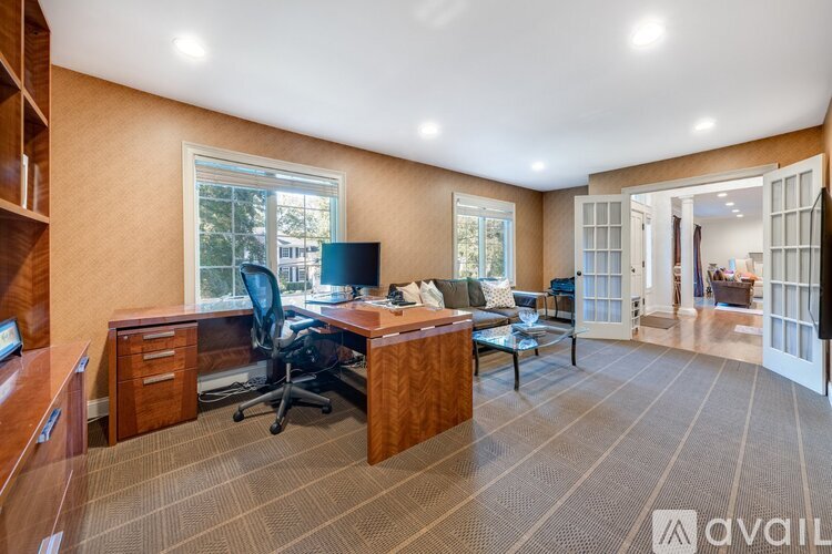 A spacious office room with a desk, chairs, and a window.