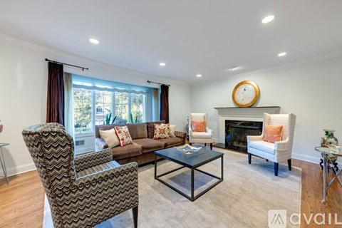 A living room with a fireplace and a chair with a chevron pattern.