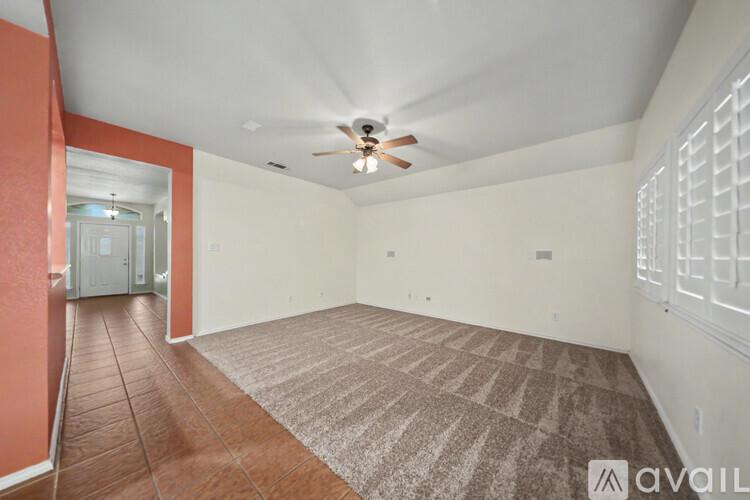A spacious room with a carpeted floor and a large mirror on the wall.