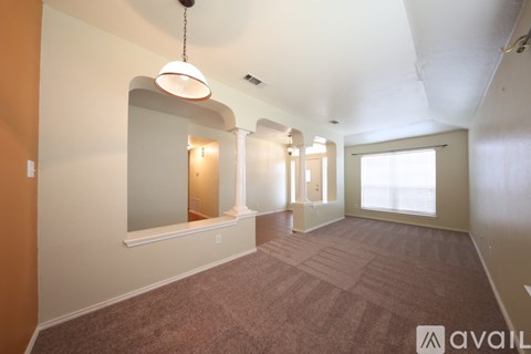 A spacious room with a carpeted floor and a large mirror on the wall.