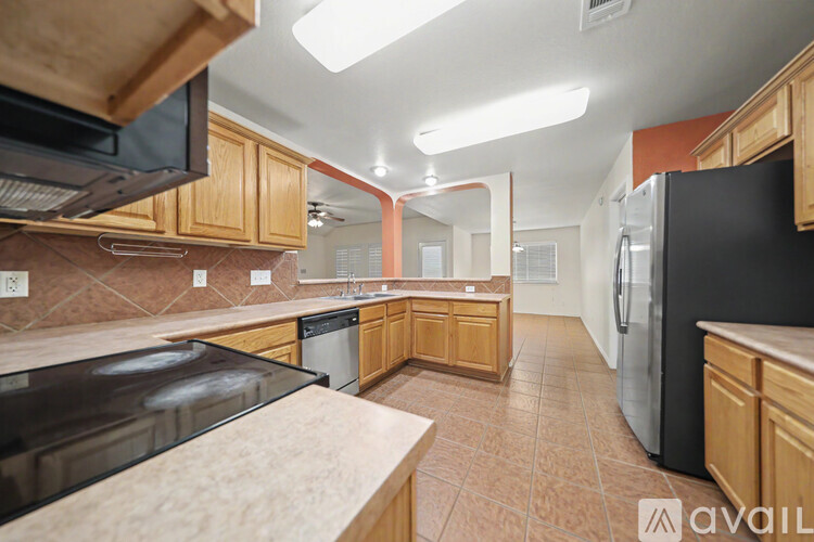 A kitchen with wooden cabinets and a refrigerator.