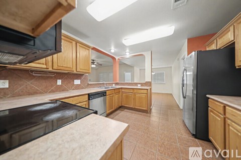 A kitchen with wooden cabinets and a refrigerator.