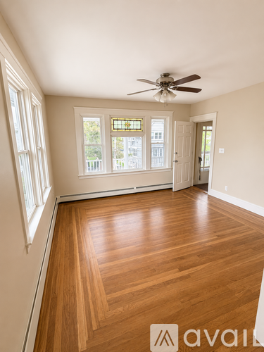 A room with wooden floors and a ceiling fan.
