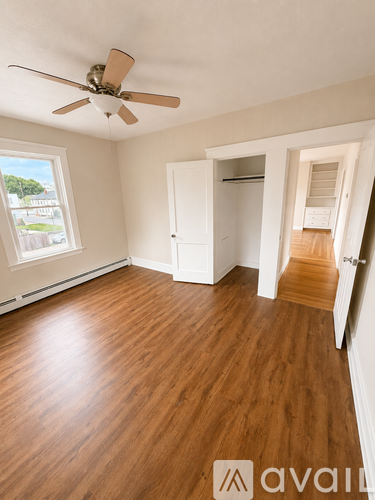 A room with wooden floors and a ceiling fan.