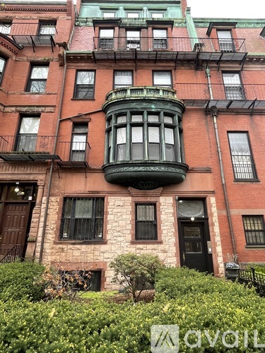 A red brick building with a green balcony in the middle.