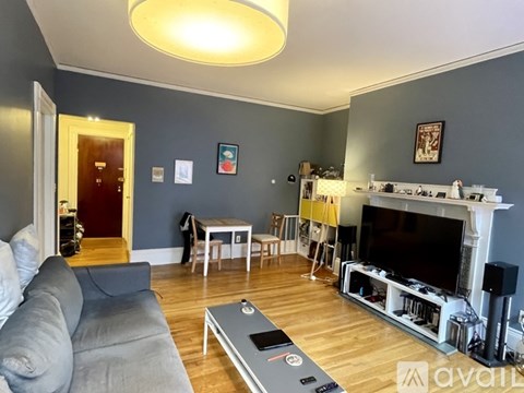 A living room with a grey couch and a fireplace.