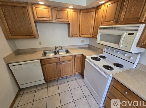 A kitchen with wooden cabinets and white appliances.