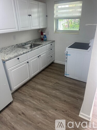 A kitchen with white cabinets and a granite countertop.