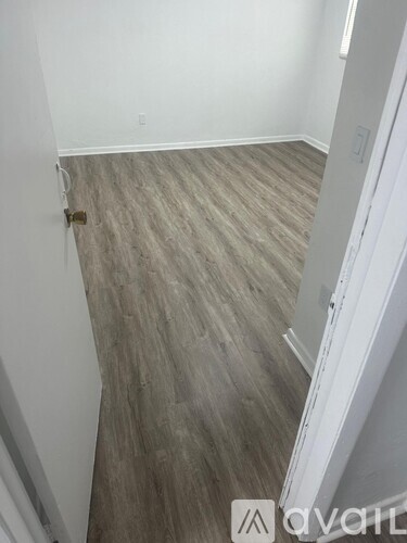 A room with a wooden floor and white walls.