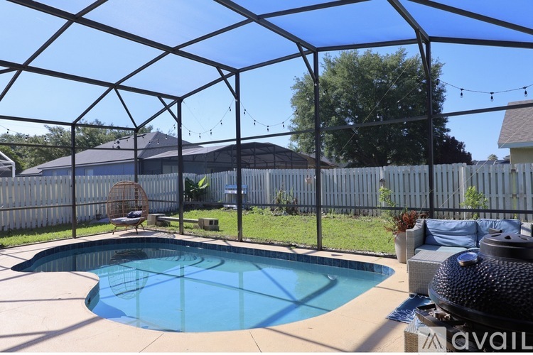 A pool with a black fence and a black chair.