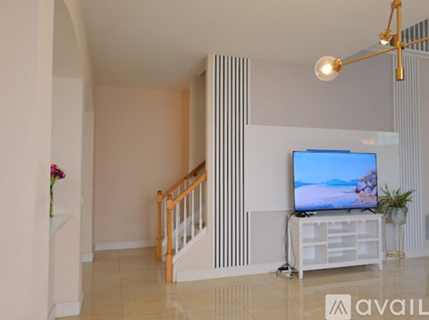 A modern living room with a television and a staircase.