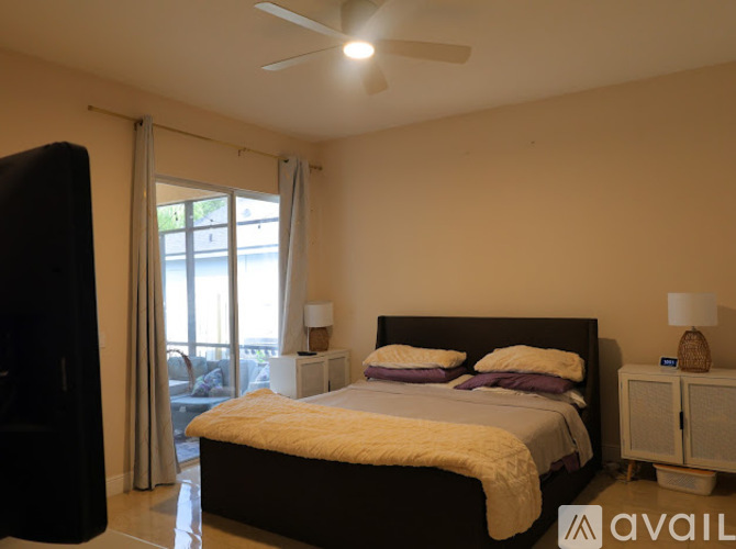 A bedroom with a large bed and a ceiling fan.