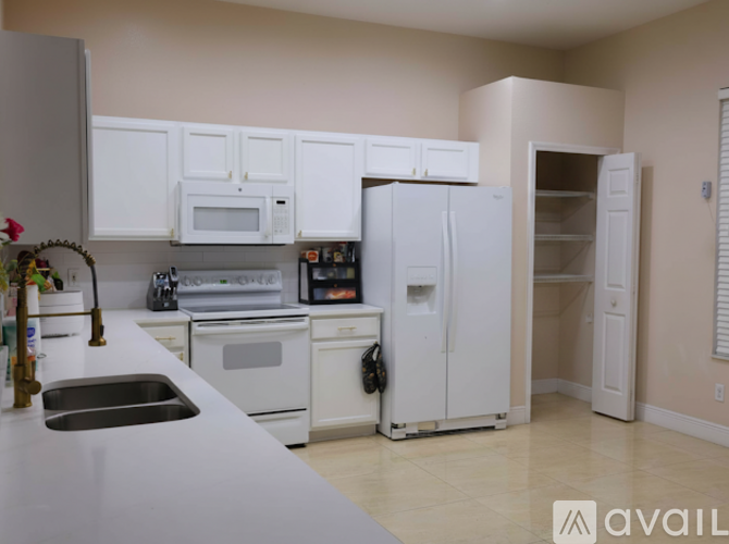A kitchen with white appliances and cabinets.