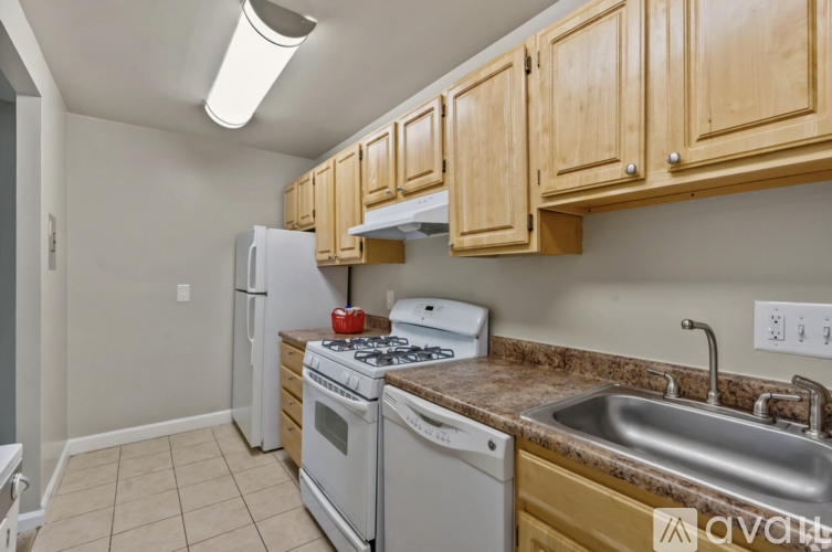 A kitchen with wooden cabinets and a white fridge.