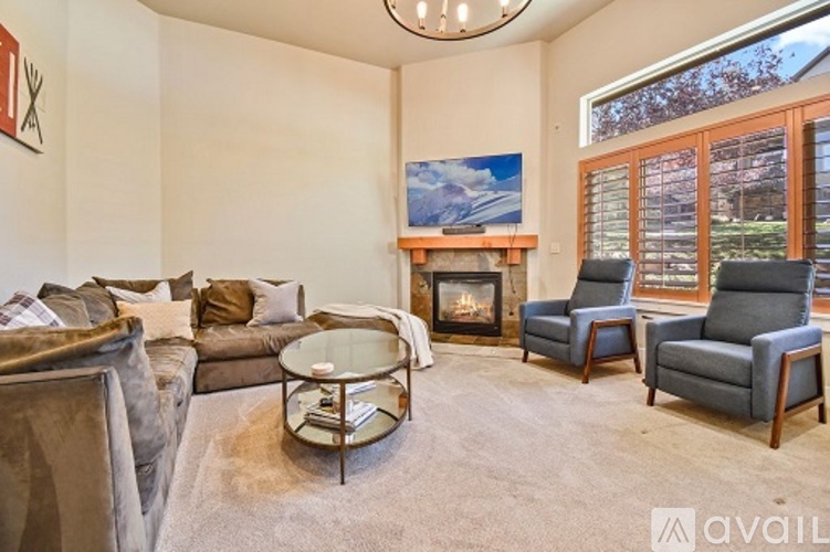 A living room with a fireplace and a painting on the wall.
